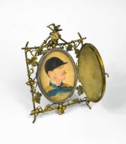 A portrait miniature of a jockey, overpainted photograph by Elliott and Fry, in an ornate mirror-