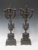 A pair of French early 20th century five branch spelter candelabra, set on twin handled urn supports