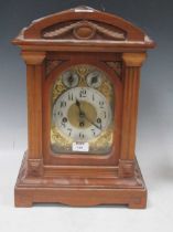 An Edwardian walnut case gong chiming mantel clock with arch top above chime/silent and slow/fast