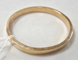 A hallmarked 15ct gold arm bangle, weight 18.5g Hollow7.5cm inner diametermultiple dents, quite