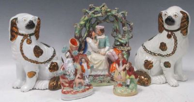 A Staffordshire pottery figure group of two young lovers in a bower; together with two further