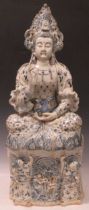 A large porcelain blue and white figure of Guanyin, seated with one hand raised, the lower hand
