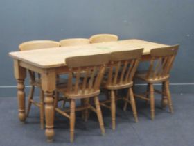 A modern pine kitchen table on turned legs. 77cm x 183cm x 76cm together with 6 pine chairs (7)