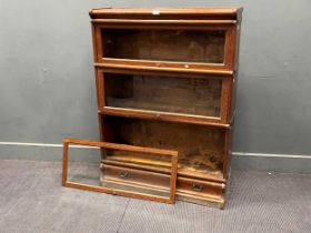 An oak Globe Wernicke sectional bookcase or display cabinet, with three glazed lift up doors,