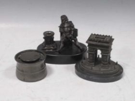 A bronze inkwell and pen holder of a drunken knight, a small bronze model of the Arc de Triomphe & a