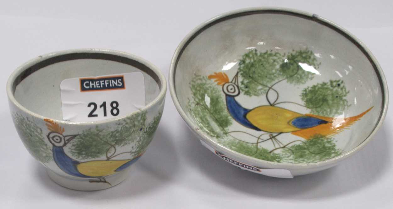 A small early 19th century pearlware teabowl and saucer decorated with a peacock