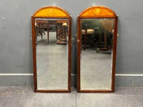 A pair of Art Nouveau period wall mirrors, the bevelled plates with arched inlaid panels above (