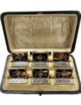 A cased set of six early 20th century silver and tortoiseshell menu holders,