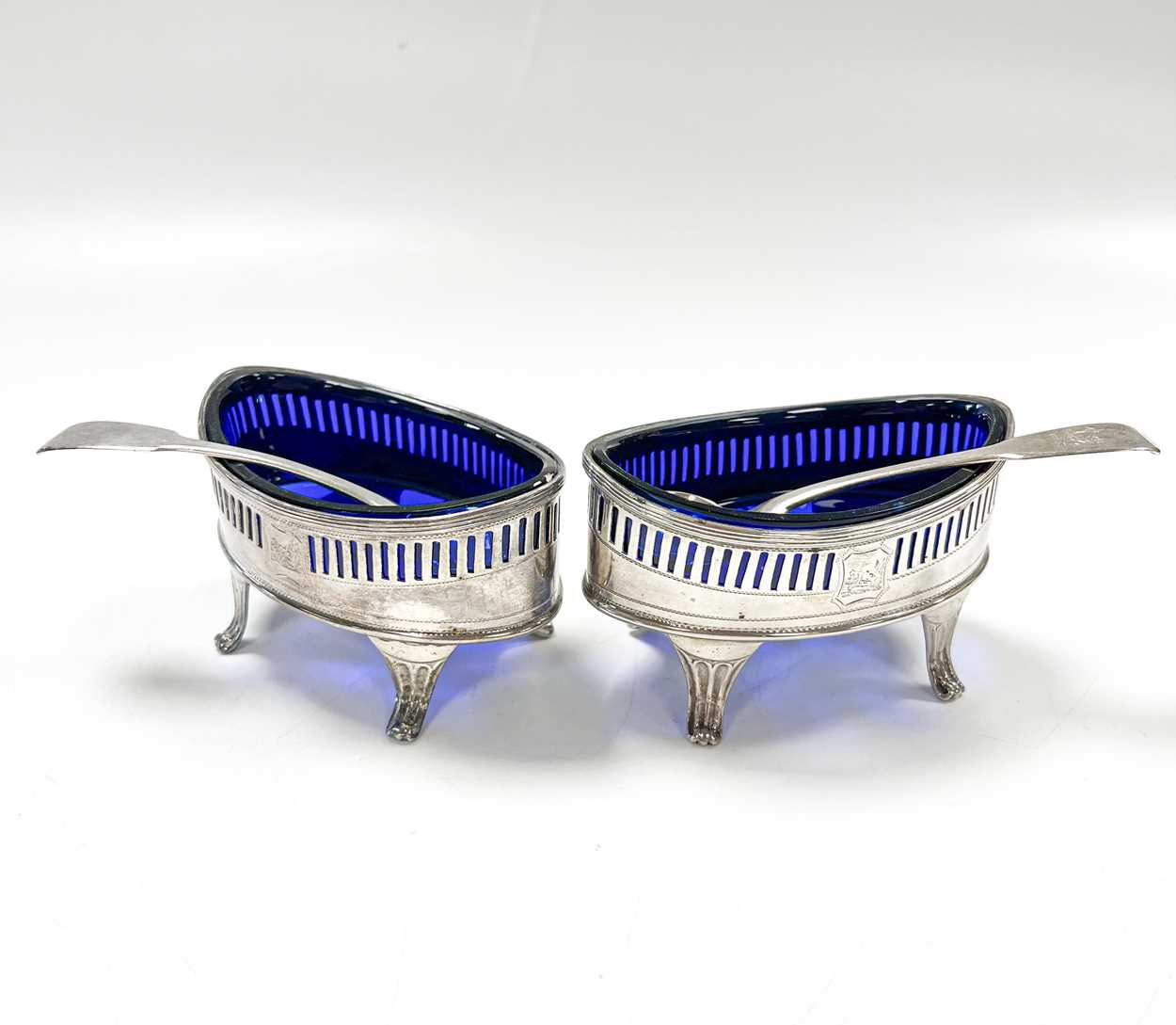 A pair of George III 18th century silver salts with later spoons,