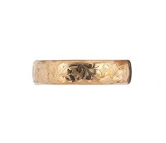 A late 20th century 9ct gold half engraved bangle,