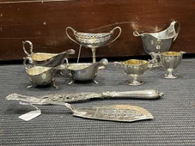 A collection of silverware including a sugar bowl and matching milk jug, four sauce boats, a two