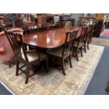 An American reproduction mahogany twin pedestal dining table and set of eight dining chairs with