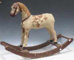 A small early 20th century rocking horse, covered in horse hair on brown painted bow rockers 63 x 86