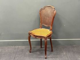 A late 19th century continental shaped walnut and caned salon chair on cabriole legs