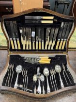 A wooden canteen containing a selection of silverplated flatware