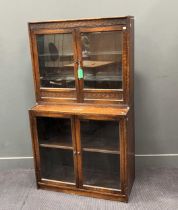 An oak two section glazed door bookcase circa 1930, 155 x 87 x 39cm