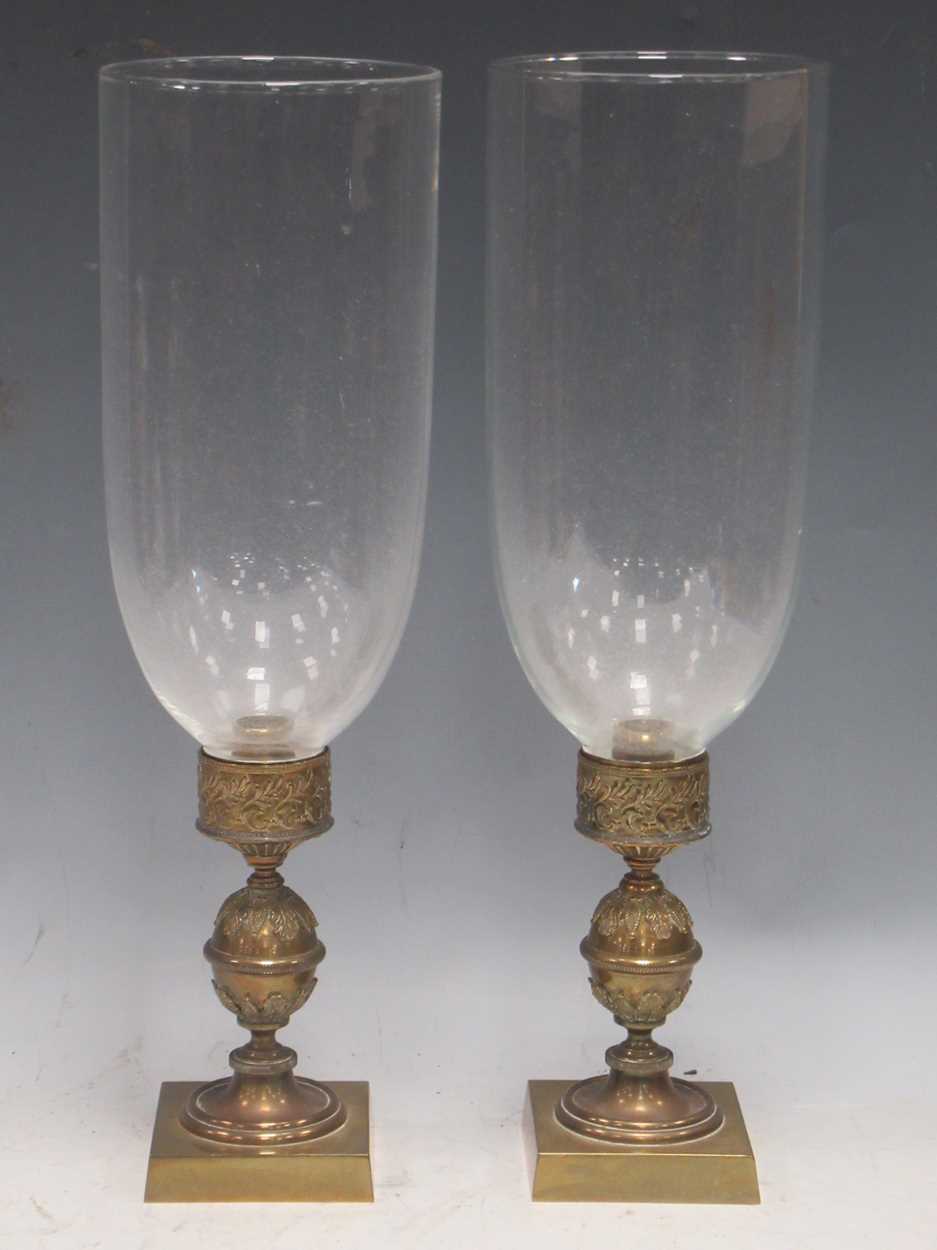 A pair of Regency brass candle holders or hurricane lamps with glass shades the glass shades are