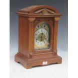 An Edwardian walnut case gong chiming mantel clock with arch top above chime/silent and slow/fast