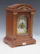 An Edwardian walnut case gong chiming mantel clock with arch top above chime/silent and slow/fast