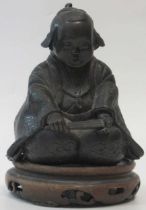 A Japnese bronze of a kneeling boy, on a wooden base, 10cm high