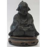 A Japnese bronze of a kneeling boy, on a wooden base, 10cm high