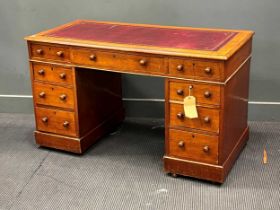 An Edwardian mahogany pedestal desk with inset red leather writting surface over a combination of