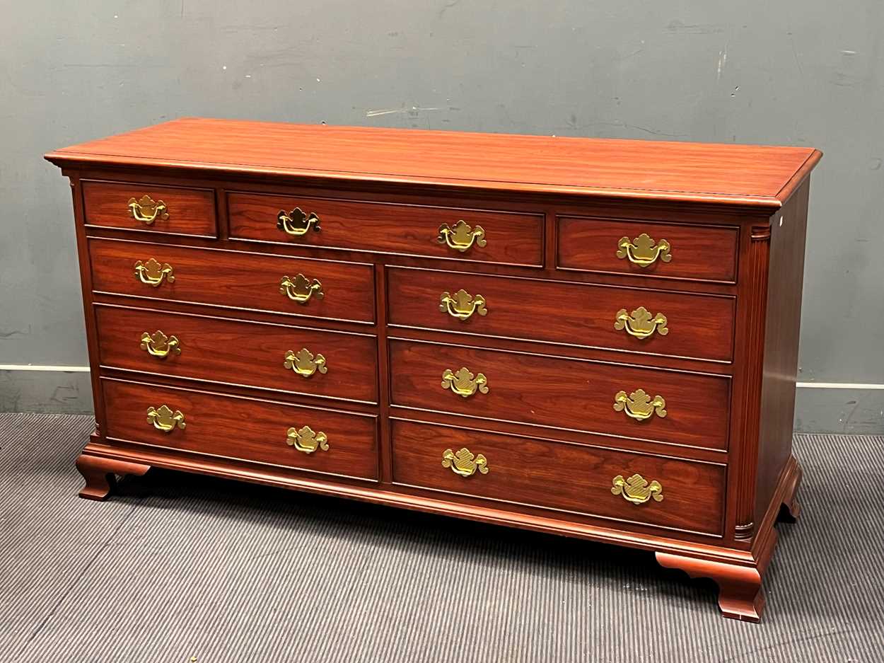 An American modern wild black cherry long chest of 9 drawers with gilt brass handles, by Henkel