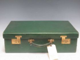 A early 20th century green scotchgrained leather suitcase with watered taffetta divided interior.