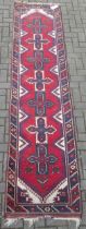 A caucasian wool runner, with repeating medallions and geometric border 306 x 74cm