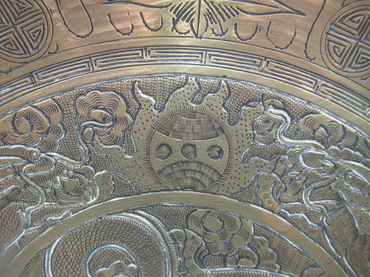 A Chinese circular brass dish on carved wood stand, early 20th century, decorated in relief with - Image 2 of 10