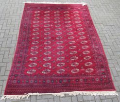 A Bokhara red ground wool rug 301 x 200cm