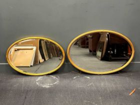 Two similar Regency style gilt framed oval wall mirrors, with ribbon tied reed moulded frames, 54