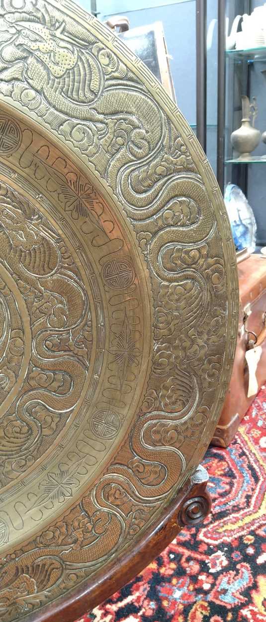 A Chinese circular brass dish on carved wood stand, early 20th century, decorated in relief with - Image 8 of 10