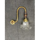 A Victorian brass and glass gas wall light, of swan neck form and moulded shade (adapted for