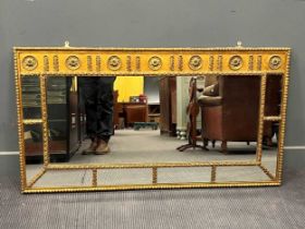 A neoclassical style gilt painted sectional overmantel mirror, the freize decorated with repeating