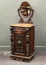 A Victorian Jacobean revivial carved oak shaving stand, the oval mirror within shaped supports