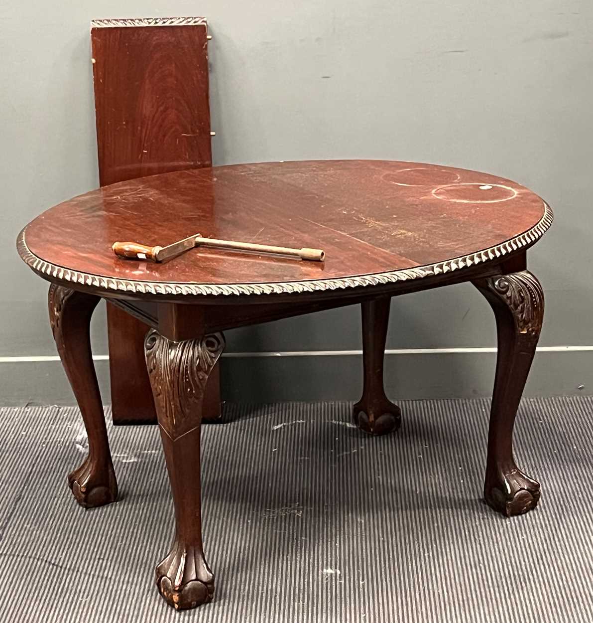 A Edwardian mahogany oval extending dining table with single leaf and winder on claw-and-ball feet