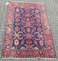 A Persian blue ground wool rug with red floral border 202 x 130cm