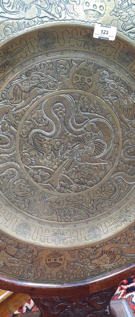 A Chinese circular brass dish on carved wood stand, early 20th century, decorated in relief with - Image 6 of 10