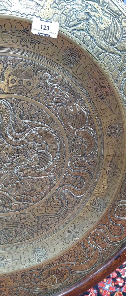 A Chinese circular brass dish on carved wood stand, early 20th century, decorated in relief with - Image 7 of 10
