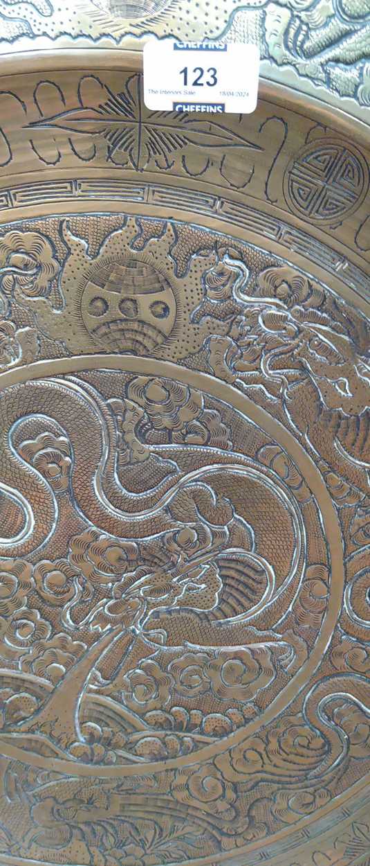 A Chinese circular brass dish on carved wood stand, early 20th century, decorated in relief with - Image 9 of 10