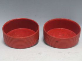 A pair of ribged red lacquer coasters (2)