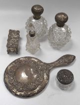 A silver hand mirror, a pair of silver topped glass scent bottles, another smaller, a silver