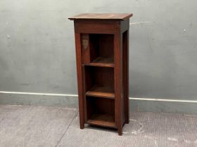 A stained wood open bookcase with Cambridge University metal mount, with three front and one side