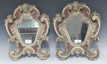 A pair of Italian cartouche shaped painted mirrors, surmounted by cherubs 35.5 x 30cm