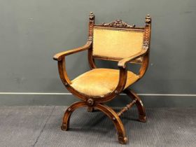 A Continental walnut Savonarola chair in the 17th century style, with carved lion mask finials 99