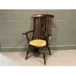 An Edwardian chair with pierced splat back and outscrolled arms, set on turned legs