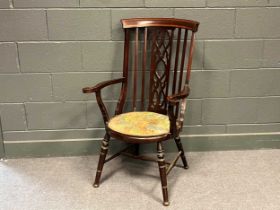An Edwardian chair with pierced splat back and outscrolled arms, set on turned legs