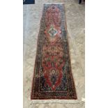 A red ground wool runner with deep pile, blue pattern design 415 x 78cm