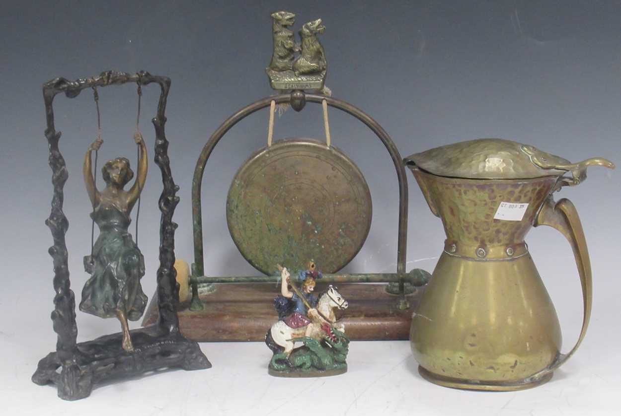 A reproduction bronze female figure on a swing after Moreau, a small brass gong on wood stand with